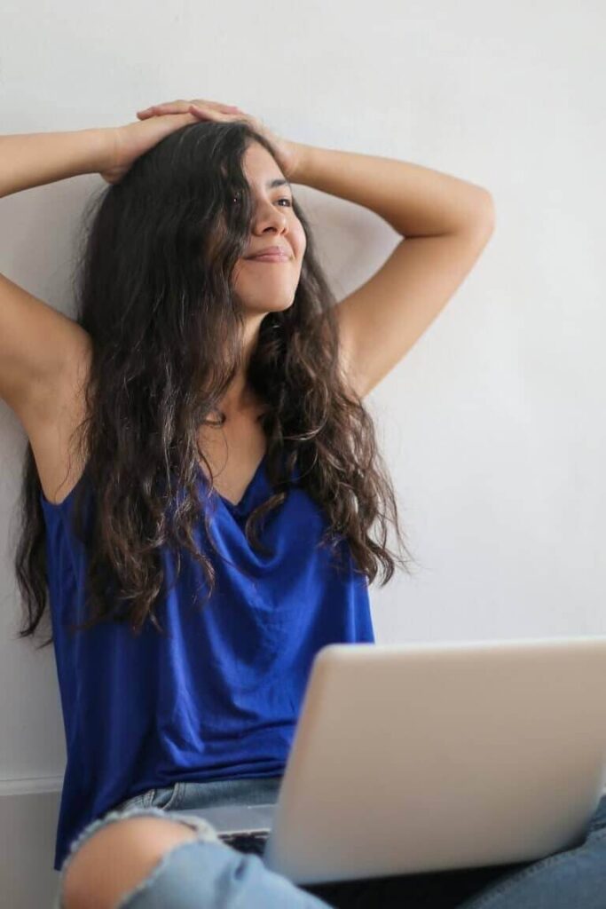 Mujer sonriente usando su portátil durante una consulta de psicología online